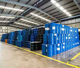 چندین بشکه آبی رنگ که در انبار سر بسته روی هم قرار گرفته اند.